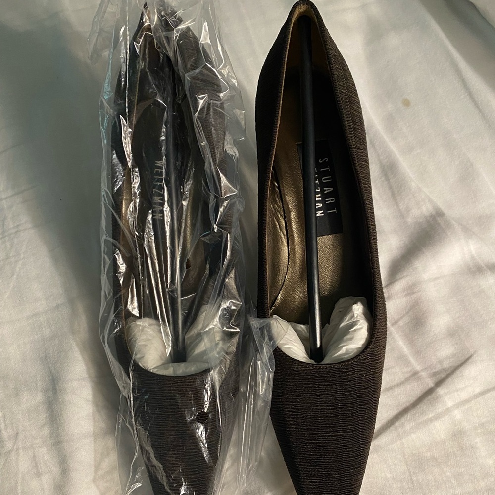 A pair of Stuart Weitzman Lotto Brown Plisse 2” heels with black plastic heels.